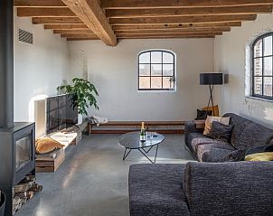 Gezellige woonkamer van Vakantiehuis in Wachtebeke, Oost-Vlaanderen, Belgi, met comfortabele bank en houtkachel.