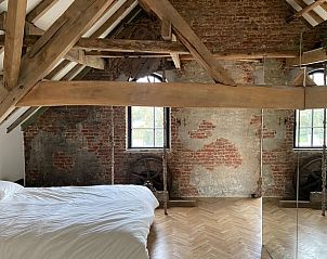 Sfeervolle slaapkamer in Vakantiehuis in Wachtebeke, Oost-Vlaanderen, Belgi, met houten balken en authentieke bakstenen muren.