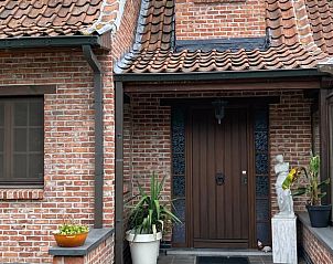 Authentieke ingang van Vakantiehuisje in Wachtebeke, Oost-Vlaanderen, met traditionele bakstenen en uitnodigende veranda.