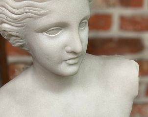 Kunstzinnige details bij Vakantiehuisje in Wachtebeke, Oost-Vlaanderen, met een elegant beeldhouwwerk in de sfeervolle binnenruimte.