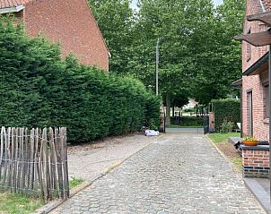 Rustieke toegangspad naar Vakantiehuisje in Wachtebeke, Oost-Vlaanderen, omgeven door weelderige natuur en serene omgeving.