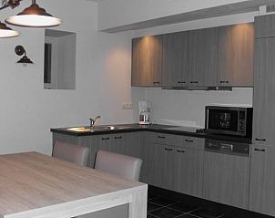 Moderne keuken in Vakantiehuisje in Herderen, Limburg, Belgi. Comfortabele binnenruimte met eettafel en stijlvolle keukenapparatuur.