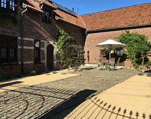 Gezellige binnenplaats van Vakantiehuis in Riemst Millen, Limburg, Belgi met rustieke stenen en uitnodigend terras.