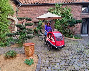 Ontspannen moment bij Vakantiehuis in Riemst Millen, Limburg, met een gezellige binnenplaats en fietsplezier in de tuin.