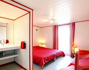 Sfeervolle slaapkamer in Chez Mari-Jo vakantiehuis, Saint-Jacques, Ardennen, Belgi met rode accenten.