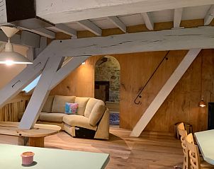 Sfeervolle woonkamer met houten balken in Vakantiehuis in Mortier, gelegen in de serene Ardennen, Luik, Belgi.